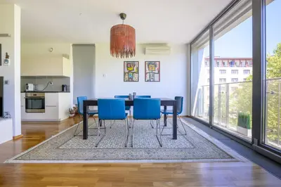 a dining room with a table and blue chairs at Sunrise Maribor apartment with private parking in Maribor