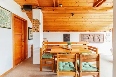 a dining room with a wooden table and chairs at Holiday Home Bela in Bohinjska Bela