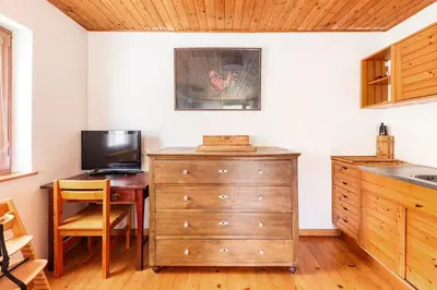 a kitchen with a dresser and a desk with a television at Holiday Home Bela in Bohinjska Bela