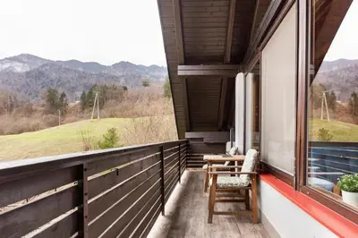 a balcony of a house with a table and chairs at Holiday Home Bela in Bohinjska Bela