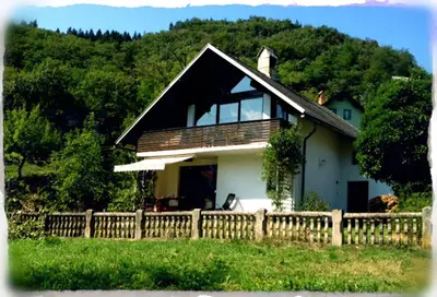 a house with a wooden fence in front of it at Holiday Home Bela in Bohinjska Bela