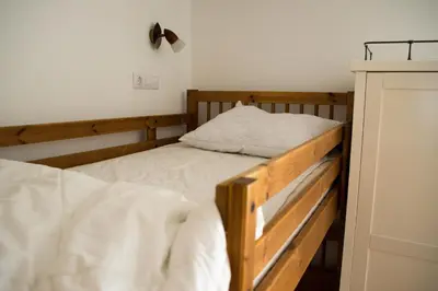 two bunk beds in a room with white sheets at Travellers' Haven Hostel in Bled