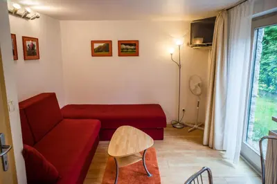 a living room with a red couch and a window at Apartments and Rooms Villa Vive in Bled