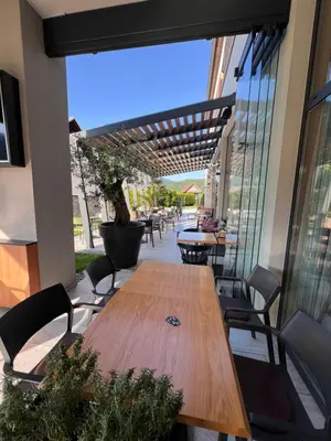 a wooden table and chairs on a patio at Na Vasi restavracija in prenočišča in Škofja Loka