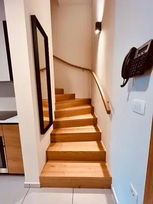 a staircase in a house with wooden steps at Na Vasi restavracija in prenočišča in Škofja Loka