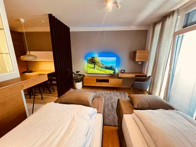 a living room with a couch and a tv at Na Vasi restavracija in prenočišča in Škofja Loka