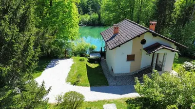a small house in the woods next to a lake at Kolpa Paradise in Metlika