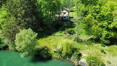 a house on a hill next to a river at Kolpa Paradise in Metlika