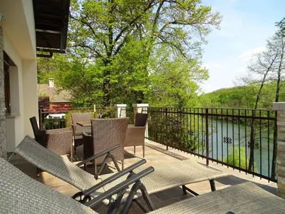 a balcony with chairs and a table and a fence at Kolpa Paradise in Metlika