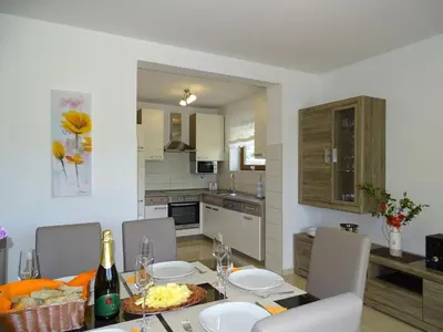 a kitchen and dining room with a table and chairs at Kolpa Paradise in Metlika