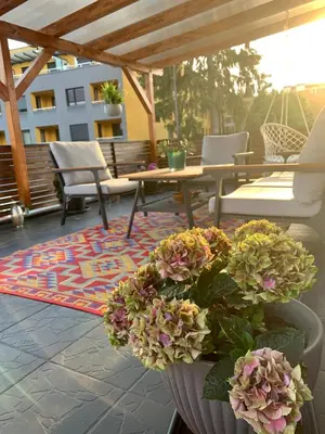 a patio with chairs and a table and flowers at Villa Hortensia in Ljubljana