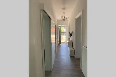a hallway with white walls and a chandelier at Villa Hortensia in Ljubljana