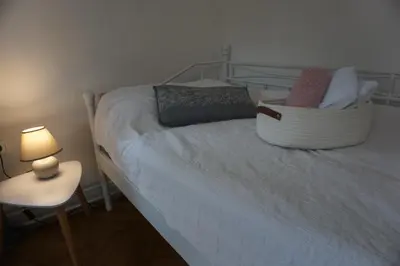 a bedroom with a bed with a lamp and a chair at Villa Hortensia in Ljubljana