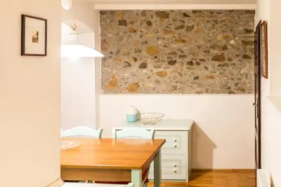 a dining room with a table and a stone wall at Stairway to the castle in Ljubljana