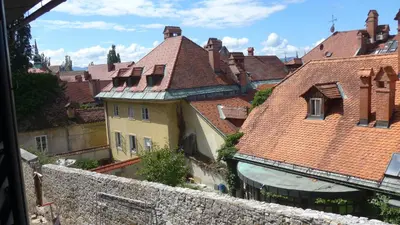 a view of roofs of buildings in a city at Stairway to the castle in Ljubljana