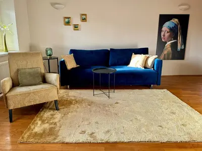 a living room with a blue couch and a chair at Stairway to the castle in Ljubljana