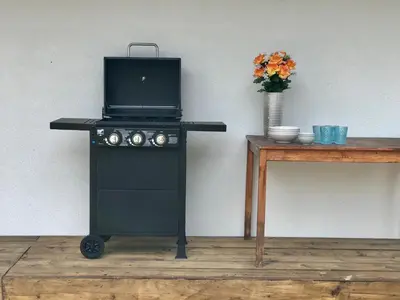 a black stove with a microwave on it next to a table at Village Apartments in Šentilj
