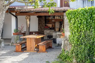 a wooden picnic table and bench in a garden at Domačija Mirko in Miren