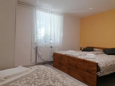 a bedroom with a bed and a large window at Domačija Mirko in Miren