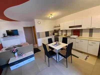 a kitchen and dining room with a table and chairs at Turistična kmetija Golej in Podčetrtek