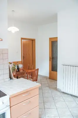 a kitchen with a table and a dining room at Entoli Apartment in Podnanos