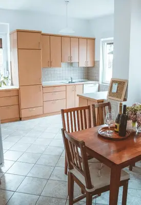 a kitchen with a wooden table and wooden chairs at Entoli Apartment in Podnanos