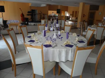 a round table with a white table cloth and chairs at Rooms Hochkraut in Celje
