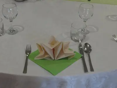 a table with a white table cloth with a plate with a napkin sidx sidx at Rooms Hochkraut in Celje