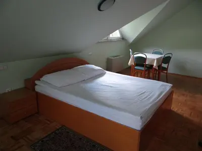 a bedroom with a bed and a table and chairs at Rooms Hochkraut in Celje