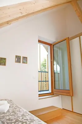 a bedroom with a window and a bed in a room at Apartment Jurijana - New 4-Bedroom Triplex with Sauna & Garden in Bohinj