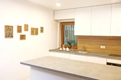 a kitchen with white cabinets and a sink at Apartment Jurijana - New 4-Bedroom Triplex with Sauna & Garden in Bohinj
