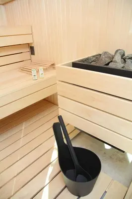 a black chair in a sauna with a tub at Apartment Jurijana - New 4-Bedroom Triplex with Sauna & Garden in Bohinj