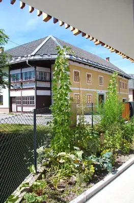 a garden in front of a house with a fence at Apartment Jurijana - New 4-Bedroom Triplex with Sauna & Garden in Bohinj