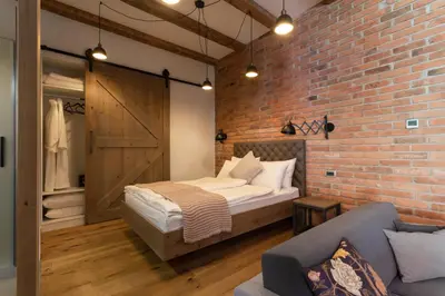 a bedroom with a bed and a brick wall at Gentry11 Rooms&More in Maribor