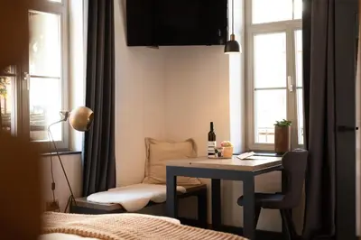a room with a table and a chair and windows at Gentry11 Rooms&More in Maribor