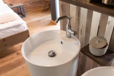 a white bathroom sink with a faucet at Gentry11 Rooms&More in Maribor