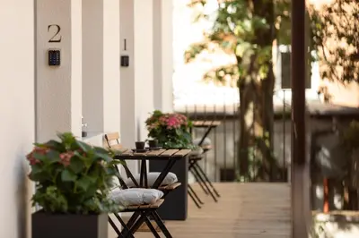 a table and chairs on a porch with plants at Gentry11 Rooms&More in Maribor