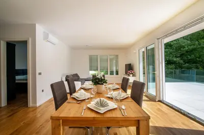 a dining room with a wooden table and chairs at Villa de Roya in Rogaška Slatina