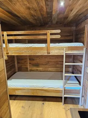 two bunk beds in a cabin with a wooden ceiling at Apartments Bedanc in Kranjska Gora