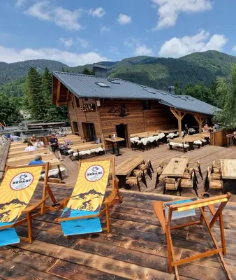 a group of chairs and tables on a wooden deck at Apartments Bedanc in Kranjska Gora