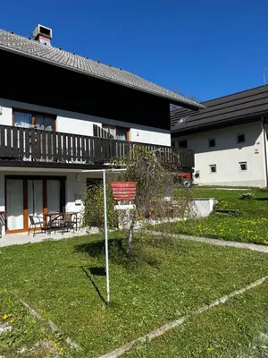 a yard with a sign in front of a house at Apartma Jure in Zgornje Gorje