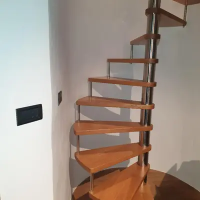 a wooden spiral staircase in the corner of a room at SMARTnoOK Rooms and Apartment in Šmartno