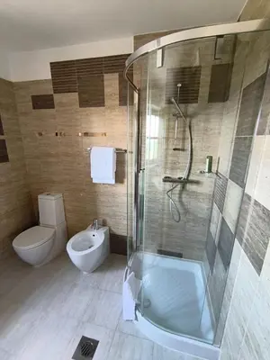 a bathroom with a shower and a toilet and a sink at SMARTnoOK Rooms and Apartment in Šmartno