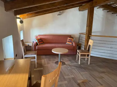 a living room with a couch and a table and chairs at SMARTnoOK Rooms and Apartment in Šmartno