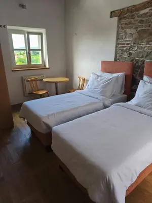 a room with two beds and a table with chairs at SMARTnoOK Rooms and Apartment in Šmartno