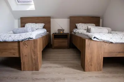 two twin beds in a room with a table at Turistična kmetija Sirk in Zgornja Velka