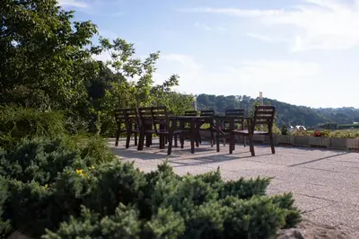a group of wooden chairs sitting around a table at Turistična kmetija Sirk in Zgornja Velka