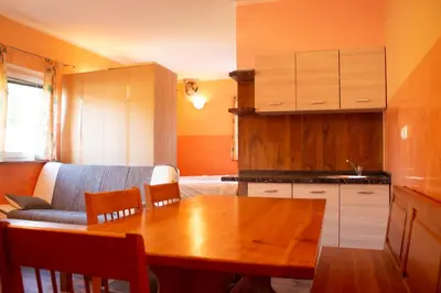 a kitchen with a wooden table and a couch at Turistična kmetija Sirk in Zgornja Velka
