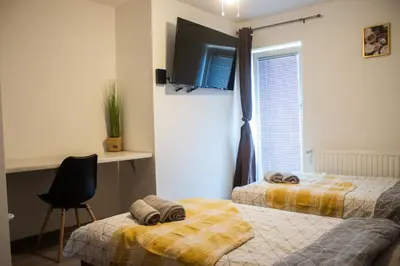a bedroom with two beds and a tv on the wall at Turistična kmetija Sirk in Zgornja Velka