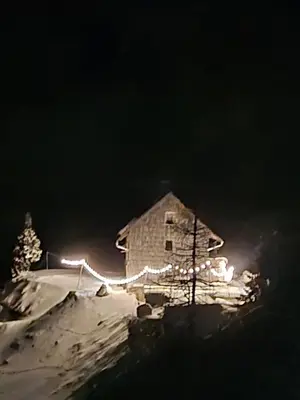a building with christmas lights on it at night at Apartment in the heart of nature in Bohinj